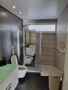 RamadaにあるMikaela Guest House 2のバスルーム(トイレ2つ、シンク付)