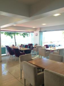 a restaurant with tables and chairs and a large window at Bayraktar Hotel in Akçakoca