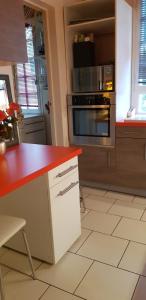 eine Küche mit einer roten Arbeitsplatte und einem Backofen in der Unterkunft Le bruit des vagues à Trouville sur mer in Trouville-sur-Mer