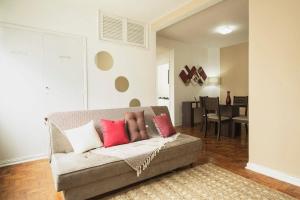 sala de estar con sofá y almohadas rojas y blancas en Dona Acibe Apartments by BnbHost, en São Paulo