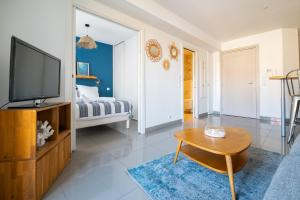 ein Wohnzimmer mit einem TV und einem Couchtisch in der Unterkunft La Maioneta Carré d'Or in Nizza