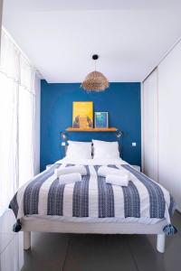 ein Schlafzimmer mit einem großen Bett mit blauer Wand in der Unterkunft La Maioneta Carré d'Or in Nizza