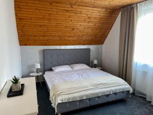 Vila Zornička في زديار: غرفة نوم بسرير كبير بسقف خشبي