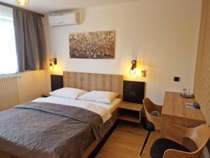 um quarto com uma cama, uma secretária e uma mesa em Pri štorklji em Moravske Toplice