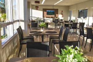 ein Restaurant mit Tischen, Stühlen und Fenstern in der Unterkunft Hotel D'Leon in Gurupi