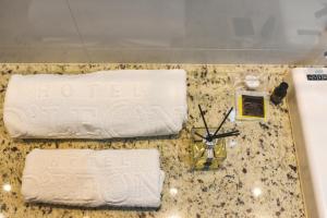 un bancone con due asciugamani e un orologio sopra di Hotel D'Leon a Gurupi