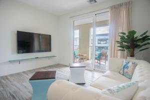 a living room with a couch and a tv at The Cove - Condo Hotel - Palm Beach Strip in Palm-Eagle Beach