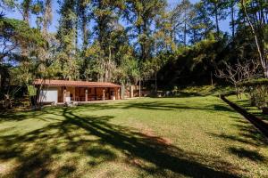 a house in the middle of a large grass field at Sitio em São Roque by Bnbhost in São Roque