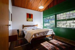 a bedroom with a bed and a green wall at Sitio em São Roque by Bnbhost in São Roque +78 photos