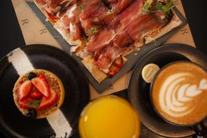 una mesa con dos rebanadas de pizza y una taza de café en ARTE HOTEL Lima, en Lima