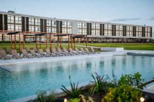 a building with chairs and a swimming pool at Midland Hotel & Resort All Inclusive in Paso de los Toros