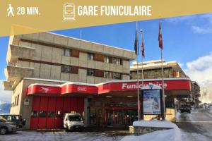 a front view of a building with a store at Primeroses I 43m2 I Balcony I Near the centre 9 min in Crans-Montana