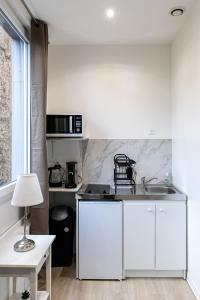 a kitchen with white cabinets and a counter top at Studio hyper centre in Strasbourg