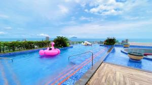 a large swimming pool with a pink inflatable raft at 光嶼海溫泉海景無邊際泳池豪華套房 in Hsin-hsing