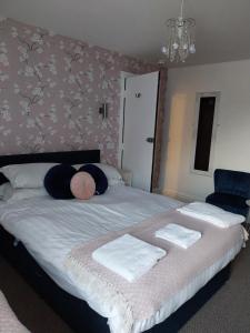 um quarto com uma cama grande e toalhas em Delamere Hotel em Blackpool