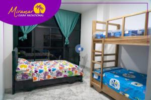 ein Schlafzimmer mit einem Etagenbett und einem Etagenbett in der Unterkunft MIRAMAR Casa Vacacional Frente al mar in Tonsupa