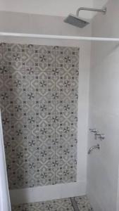 y baño con ducha y pared de azulejos. en La Justina - Casa de Campo en San Lorenzo en San Lorenzo