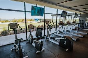 une salle de sport avec une rangée de tapis de course et de machines dans l'établissement Midland Hotel & Resort All Inclusive, à Paso de los Toros