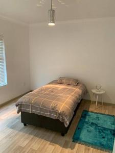 ein Schlafzimmer mit einem Bett in einem weißen Zimmer in der Unterkunft Fairways Villa @ Bunker Close in Walvis Bay