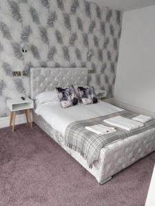 a bedroom with a bed with a headboard and pillows at Delamere Hotel in Blackpool