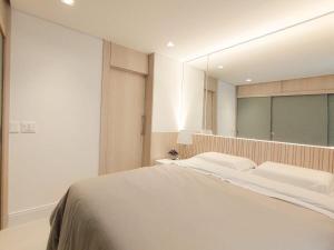 1 dormitorio con cama y espejo grande en Saint Paul Apartment by BnbHost, en São Paulo