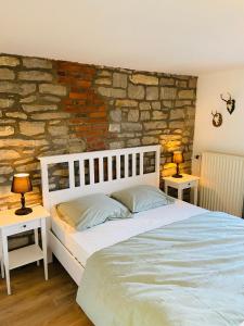 1 dormitorio con 1 cama y 2 mesas con lámparas en La Caverne, en Rochefort