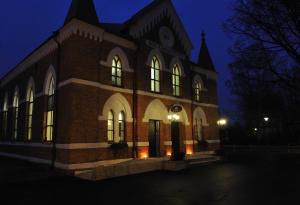 a large brick building with windows at night at Sockerslottet Hotell in Kristinehamn