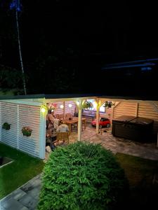 a person sitting at a table in a backyard at night at Historická vila Dom hostí in Podbrezová