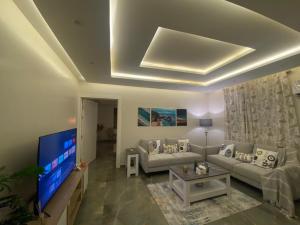a living room with a couch and a flat screen tv at شقه (غرفه+صاله)مطله على المركز المالي بدخول ذاتي in Riyadh