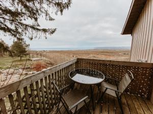a table and chairs on a deck with a view at Irish Mountain Suites in Meaford