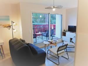 a living room with a couch and a table at Appartement moderne 3* avec balcon, proche du lac et plage, parking privatif, Wi-Fi inclus - FR-1-239-862 in Soorts-Hossegor