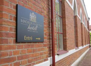 un cartello sul lato di un edificio di mattoni di Sockerslottet Hotell a Kristinehamn