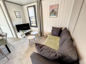 ein Wohnzimmer mit einem Sofa und einem TV in der Unterkunft Chalet Jullouville, 4 pièces, 7 personnes - FR-1-361-463 in Jullouville-les-Pins