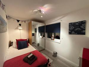 een slaapkamer met een bed met een rode deken bij Craster Crew House in Craster