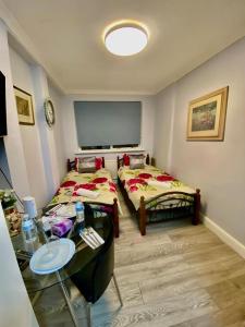 a room with two beds and a table in it at Ground floor Studio Flat In London in London