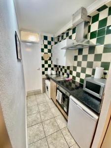 a kitchen with green and white checkered walls at Ground floor Studio Flat In London in London