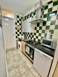 a kitchen with green and white checkered walls at Ground floor Studio Flat In London in London