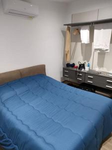 ein Schlafzimmer mit einem blauen Bett und einer Kommode in der Unterkunft The most beautiful view of Mussomeli in Mussomeli