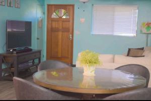 sala de estar con mesa y TV en Komohana Hale LLC, en Kailua-Kona