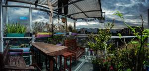 un patio con mesa, sillas y plantas en Mandala Yoga Hostel, en Bogotá