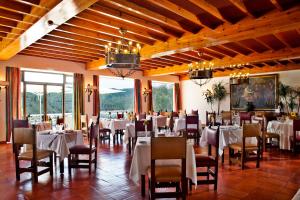 una sala da pranzo con tavoli e sedie bianchi di Lago Azul Eco Hotel a Ferreira do Zêzere