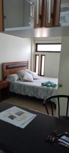 1 dormitorio con 1 cama y escritorio con mesa en Mini Loft, en Iquique