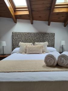 a bedroom with a large white bed with two pillows at Ensō in Penagos