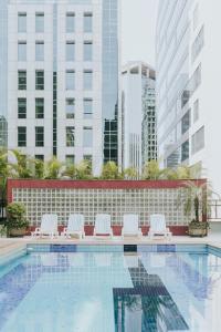 una piscina con sedie e edifici bianchi di Concept Uno Apartments by BnbHost a San Paolo