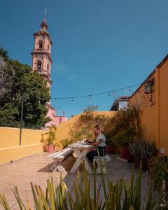 a woman sitting at a table in a courtyard at CASA DAMIANA in Lagos de Moreno