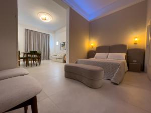una camera da letto con due letti, un divano e un tavolo di Ritucci Suite a Lecce