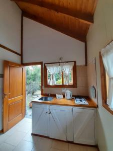 cocina con encimera, fregadero y puerta en Casa de montaña Tierras del sur I en Villa La Angostura