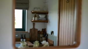 een spiegelbeeld van een keuken met een tafel en een raam bij Denham's Rest in Clitheroe