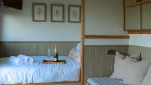 een spiegelbeeld van een bed met een fles wijn bij Denham's Rest in Clitheroe