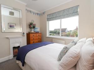 a bedroom with a bed with a fireplace and a window at Sea View House in Hornsea